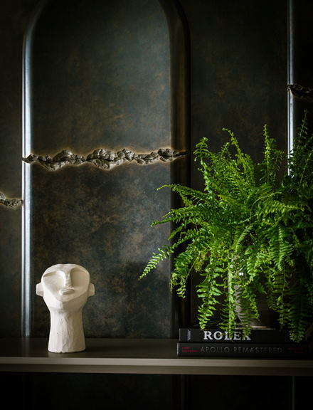 White sculpture head, Rolex book, fern plant on display, interior decor Nu Projects Dubai