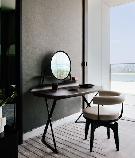 Modern vanity table with mirror and chair on a balcony overlooking the sea