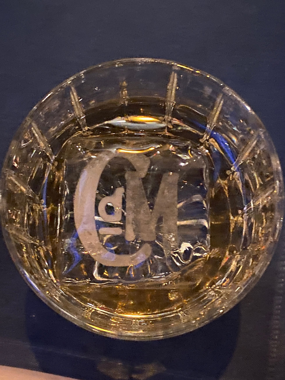 Luxury cocktail served at CdM restaurant in Corona del Mar, featuring a branded “CdM” ice cube in a cut-glass tumbler.