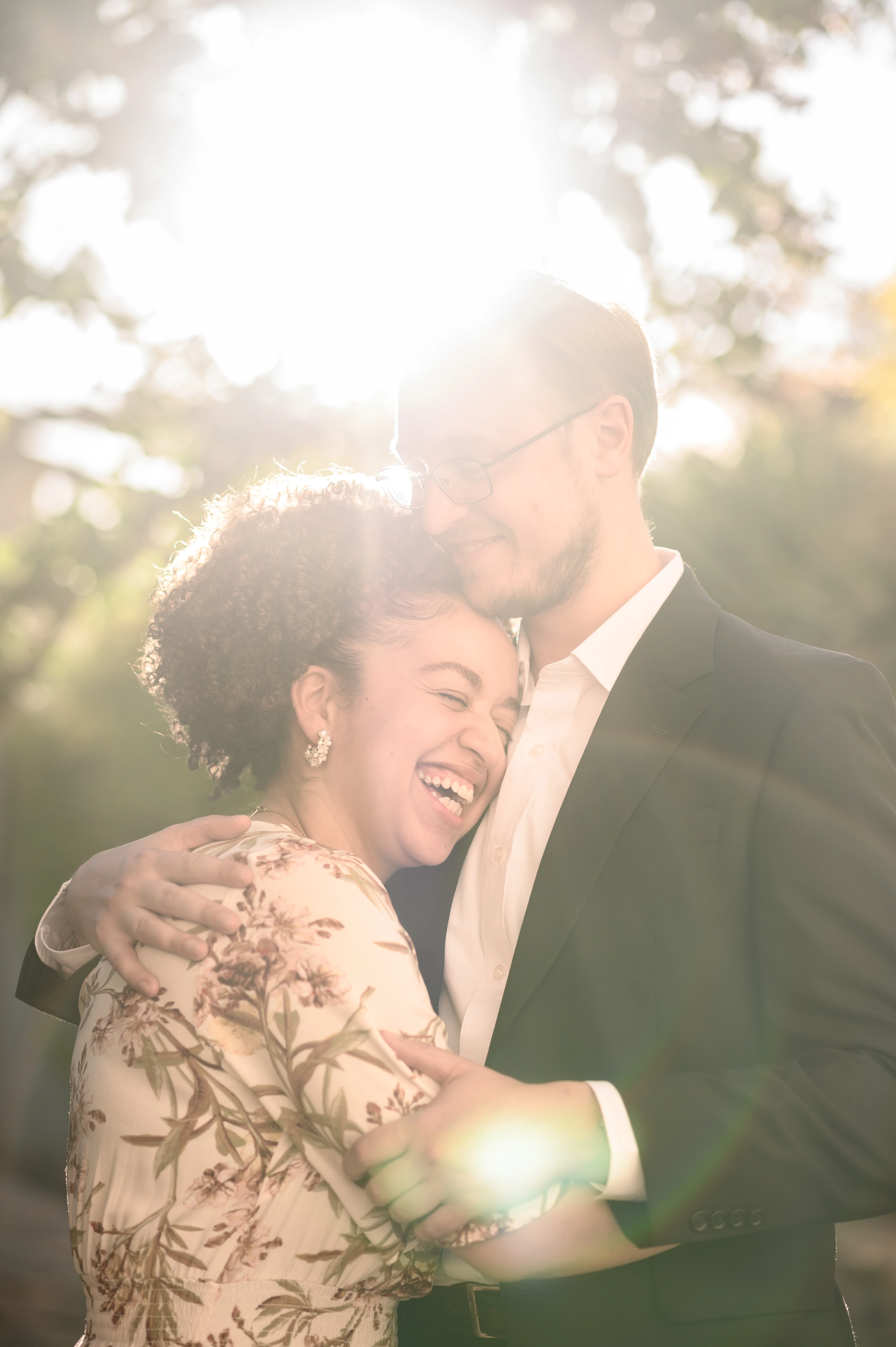 The sunlight creates a warm glow around the couple, highlighting their affectionate pose