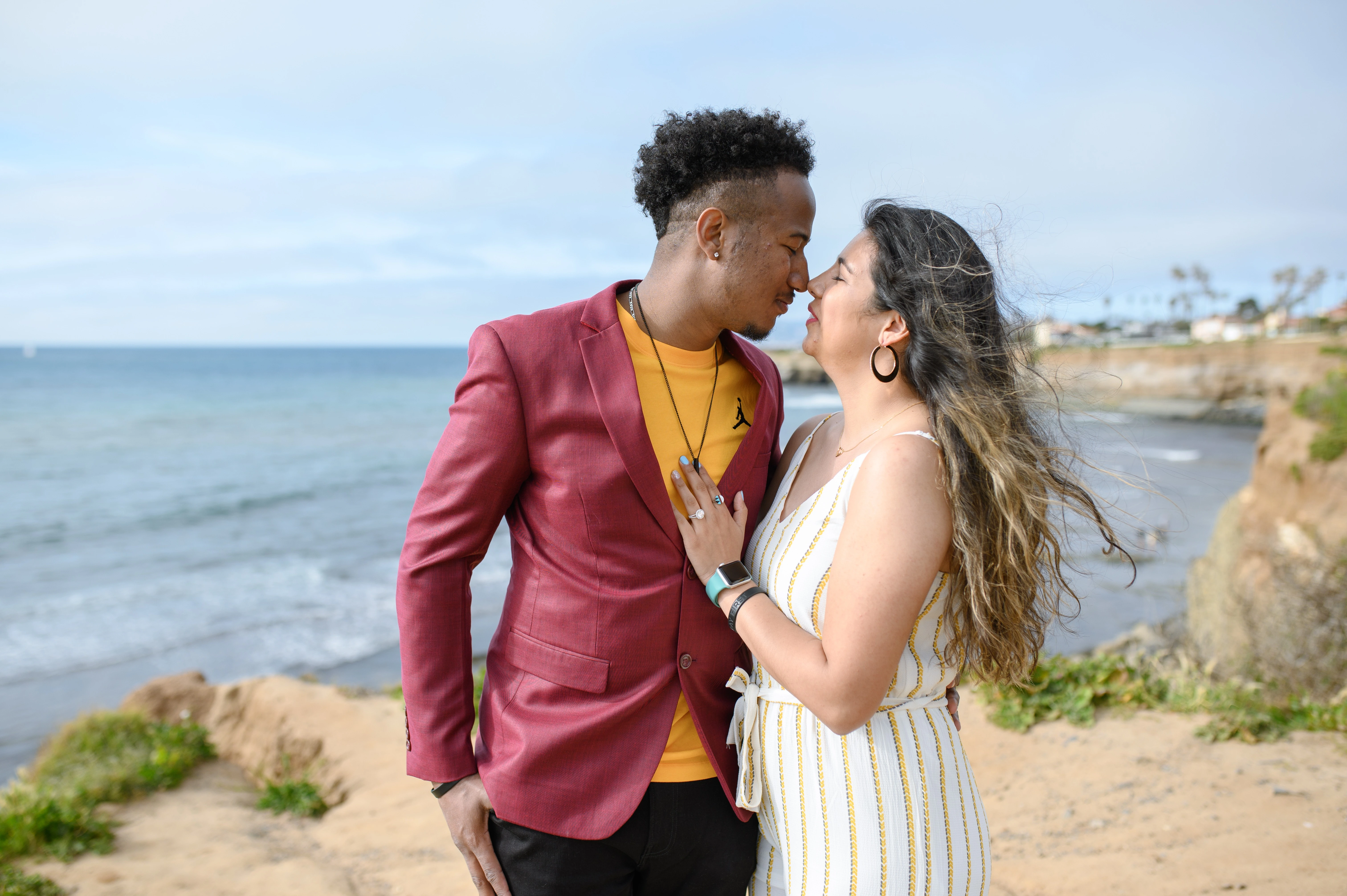 Couple sharing a tender moment at Sunset Cliffs, showcasing the joy of planning a surprise proposal. San Diego proposal photographer captures the essence of love and romance.