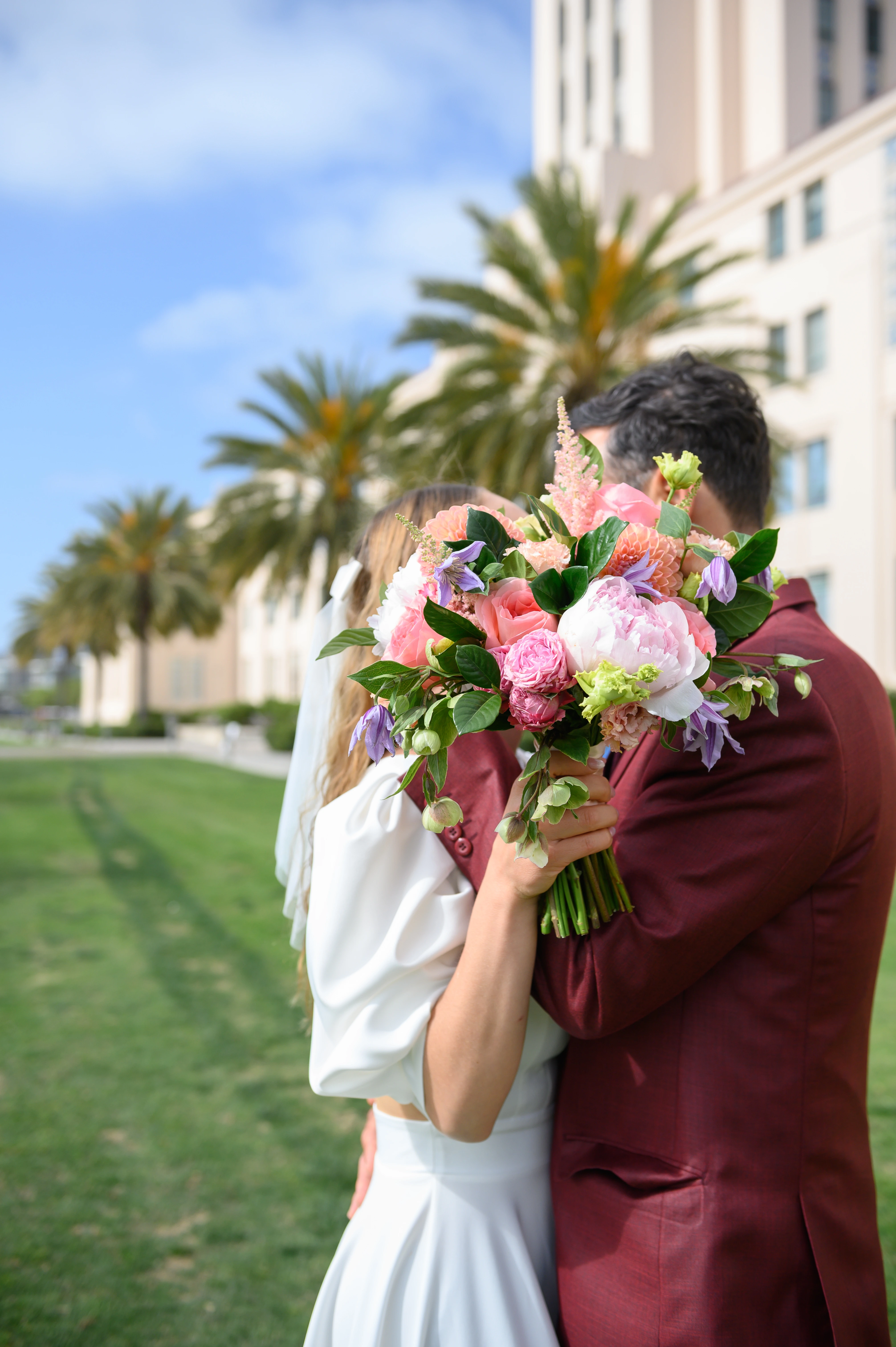 san diego elopement couple hiding behind bouquet at courthouse waterfront park
