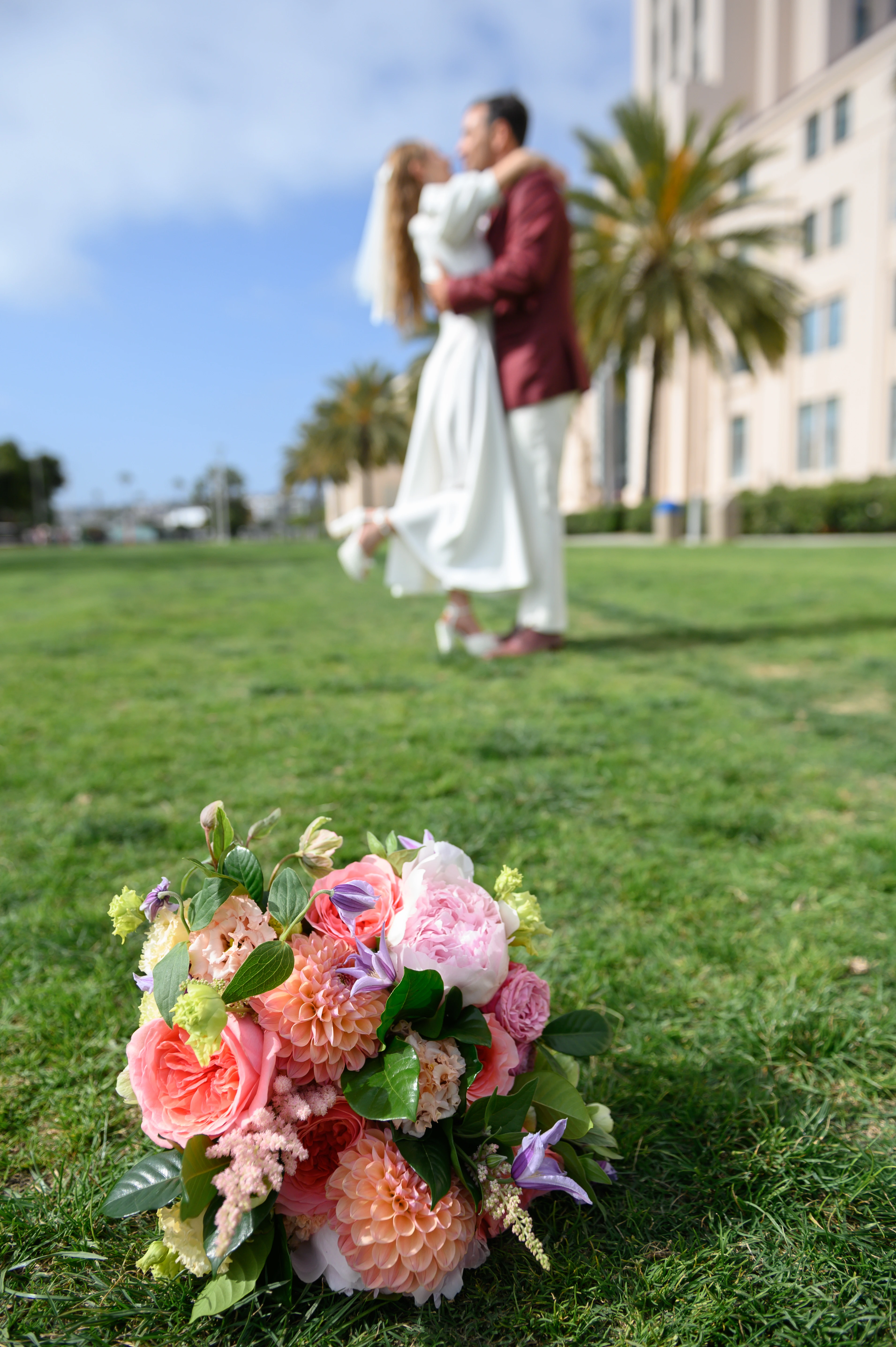 close up of bouquet and just married couple at he backround