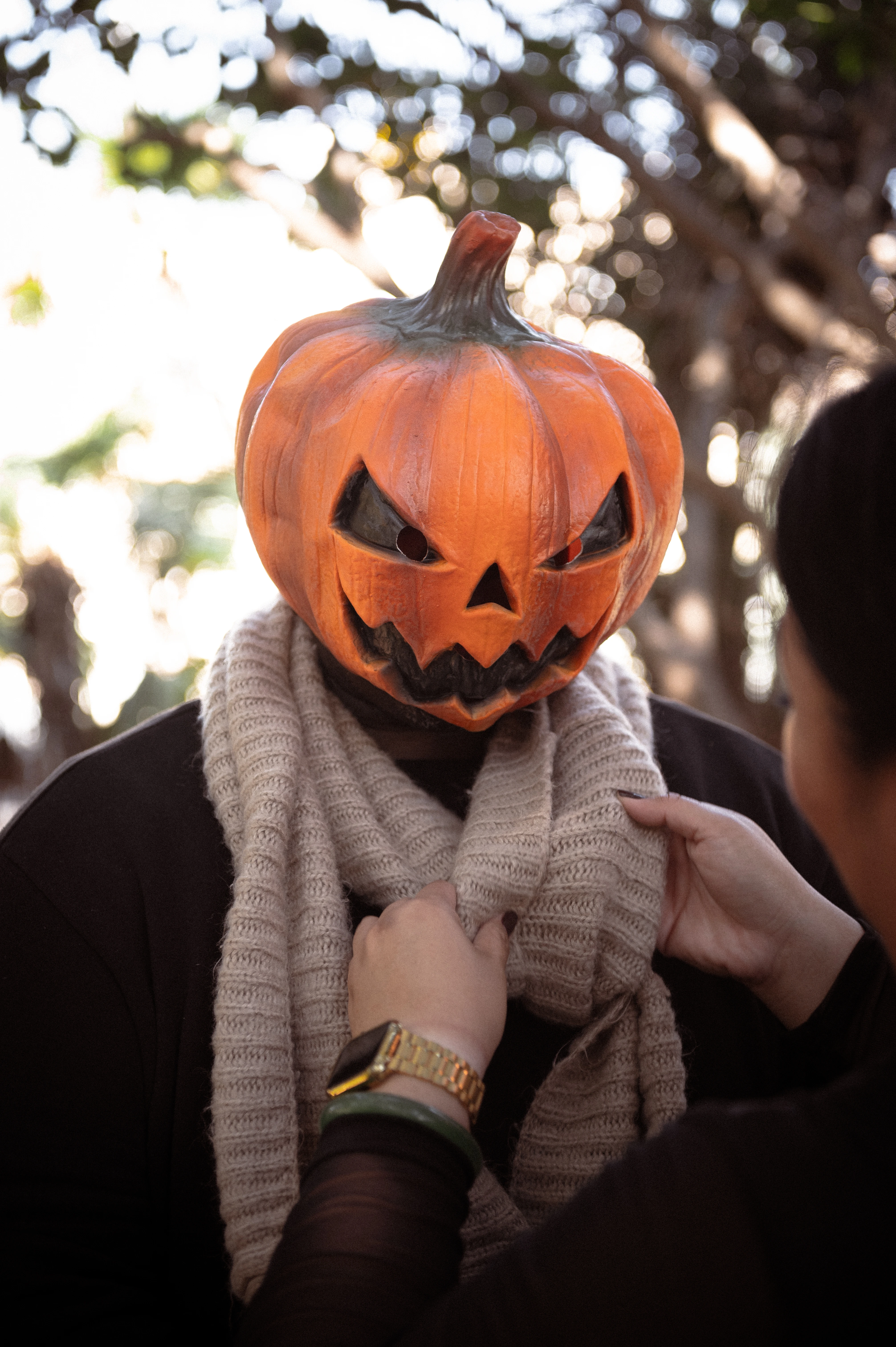 A playful moment captured during a Halloween couples photoshoot in San Diego, featuring a couple in pumpkin masks, showcasing their unique style and connection.