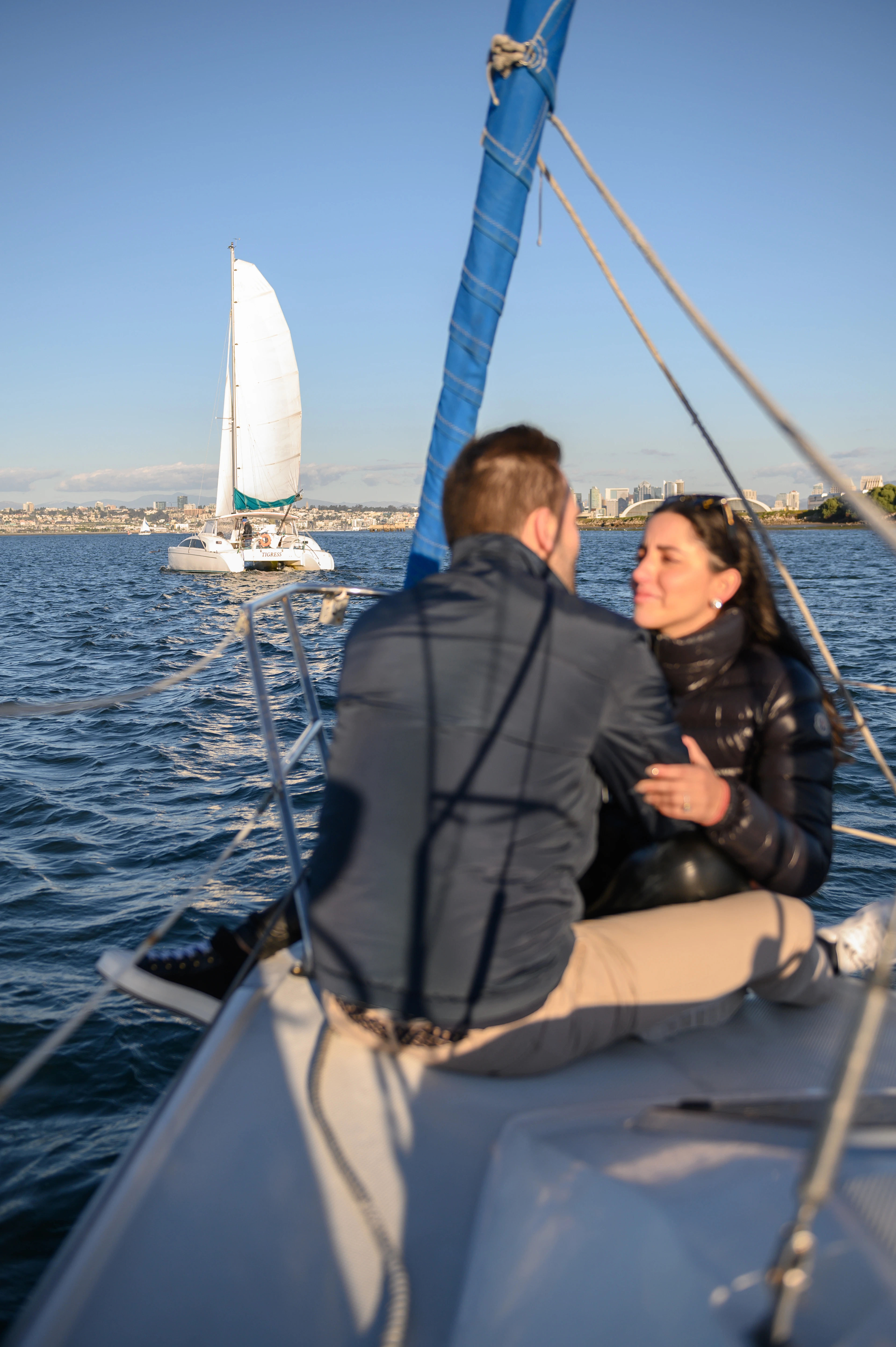 Couple joyfully displaying an engagement ring on a sailboat in San Diego, perfect for capturing unforgettable moments. Affordable San Diego proposal photographer.