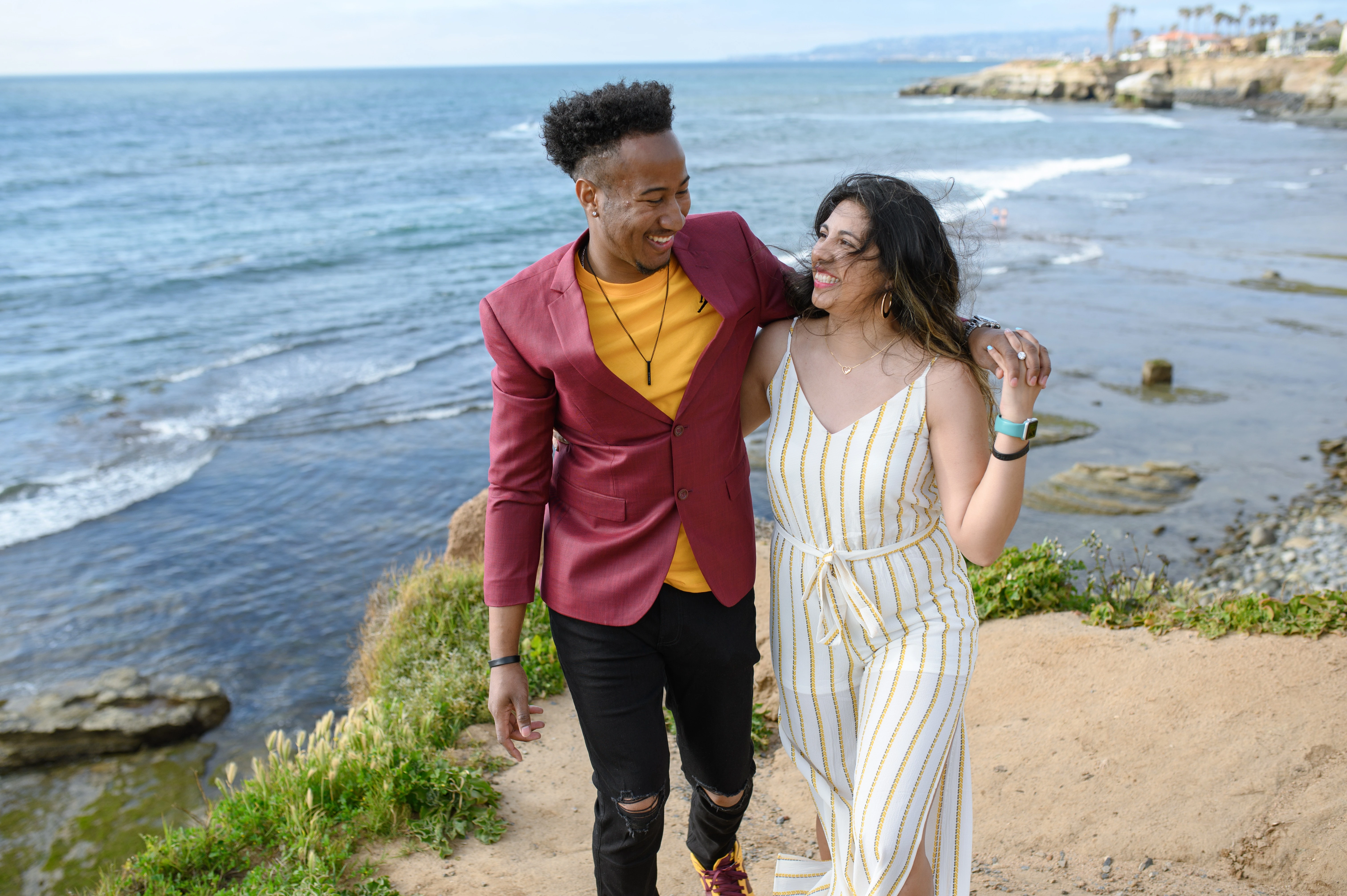 Couple walking along the coastline at Sunset Cliffs, highlighting the beauty of San Diego for romantic proposals and engagements.