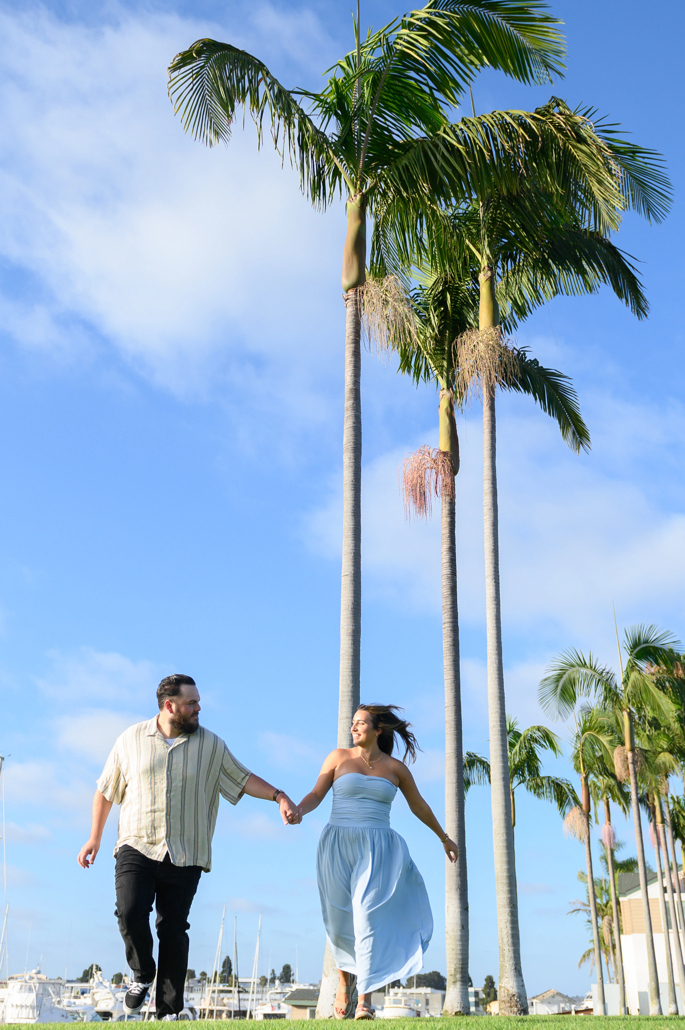 Engaged couple walking hand in hand in San Diego, ideal for showcasing the work of a romantic proposal photographer in San Diego.