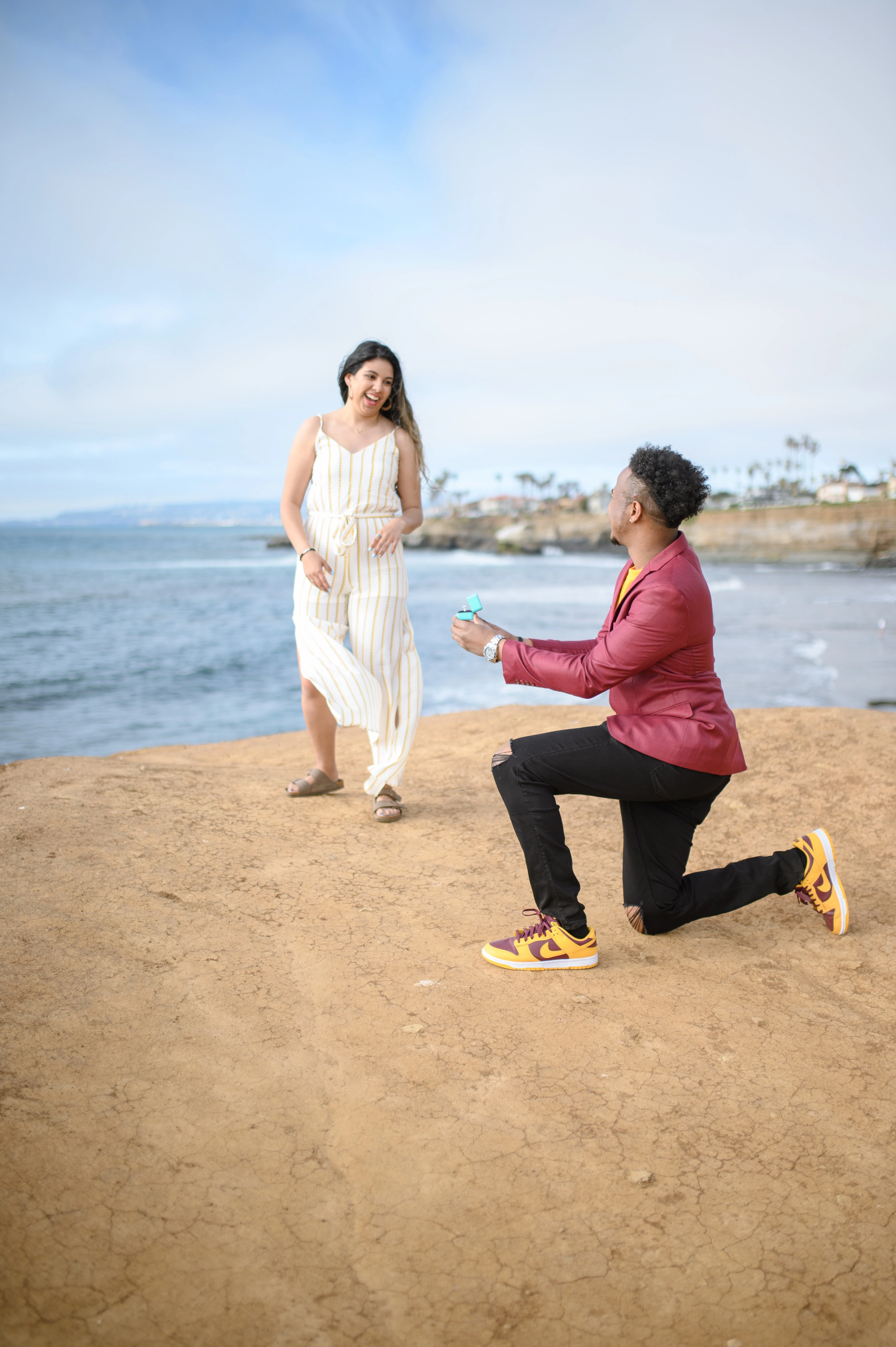 San Diego proposal photographer captures a romantic surprise proposal at Sunset Cliffs, showcasing the excitement of planning a surprise proposal.