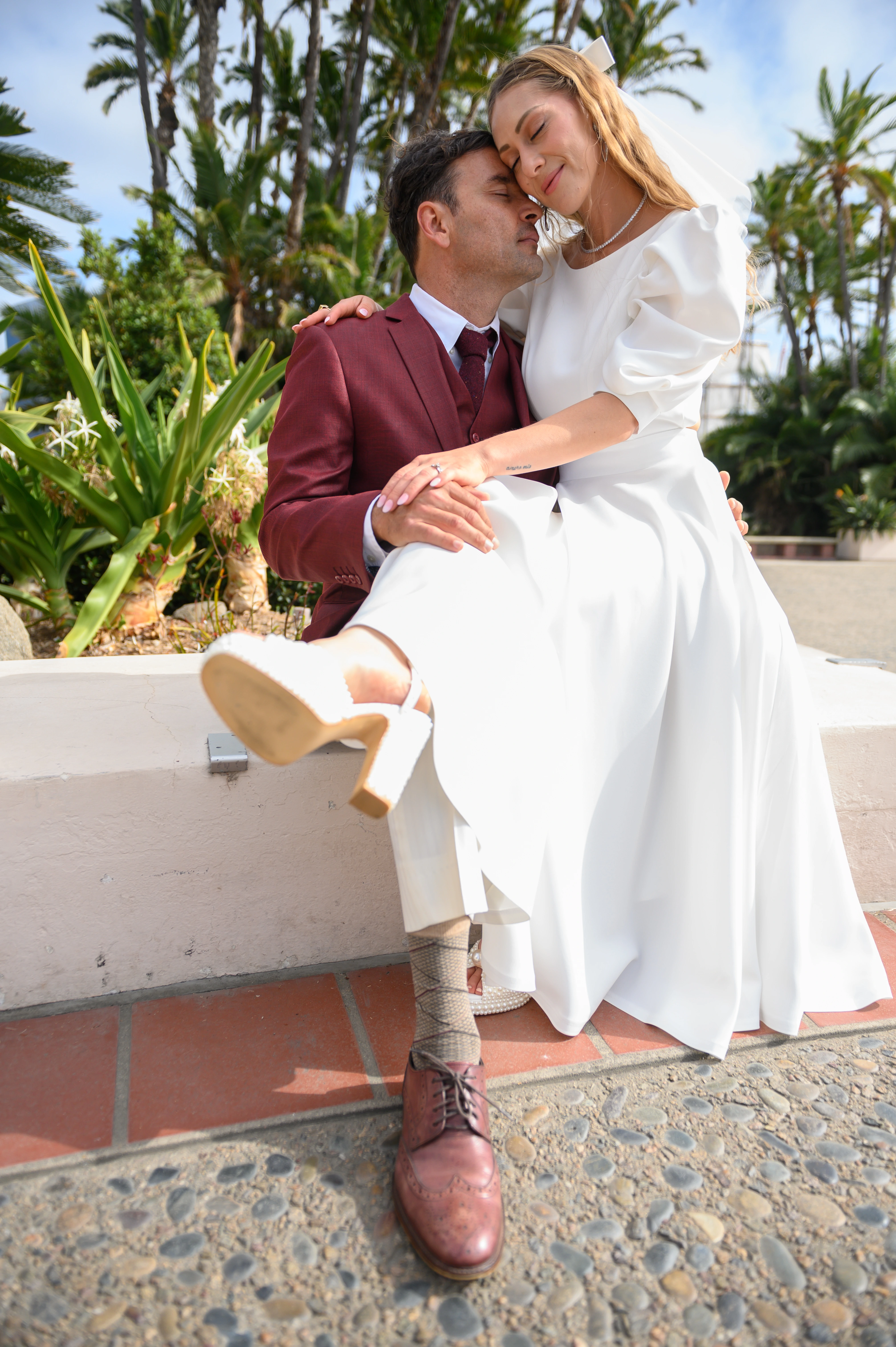 romantic moment of bride sitting in groom's lap near San Diego courthouse area