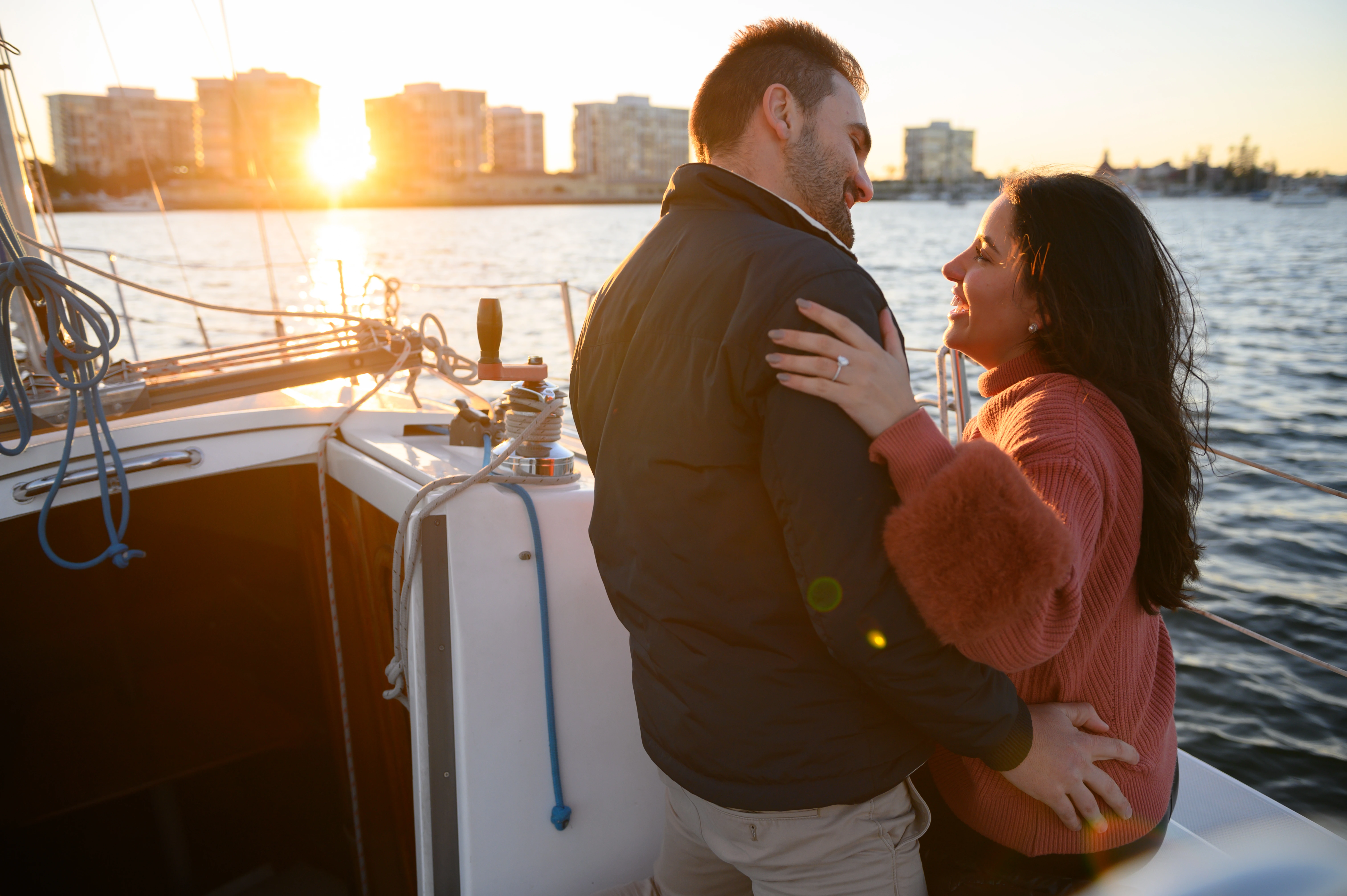 Sailboat proposal in San Diego at sunset, showcasing a couple embracing on the water, perfect for a San Diego proposal photographer.