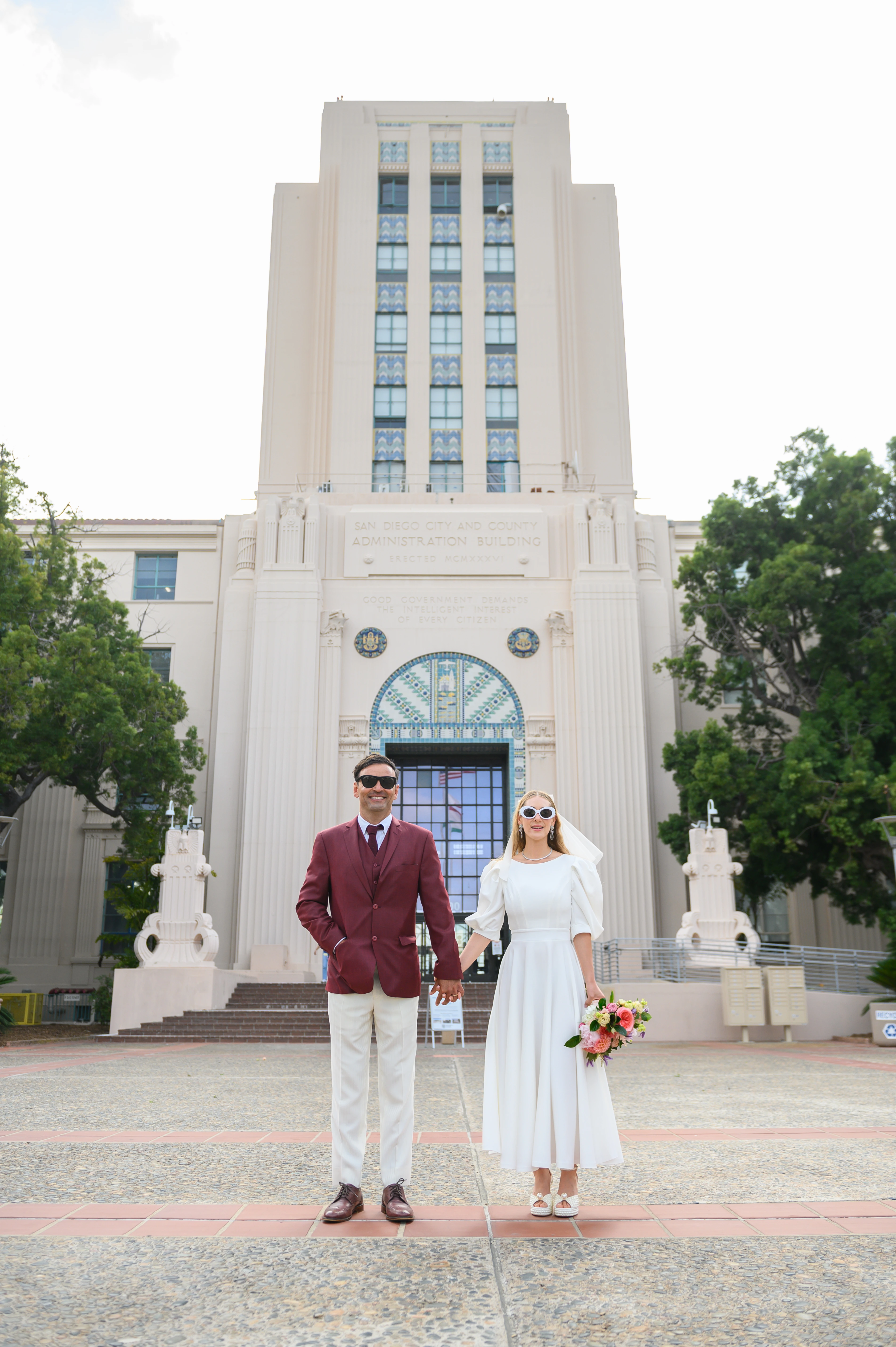 Couple holding hands in front of courthouse during relaxwd and intimate san diego elopement