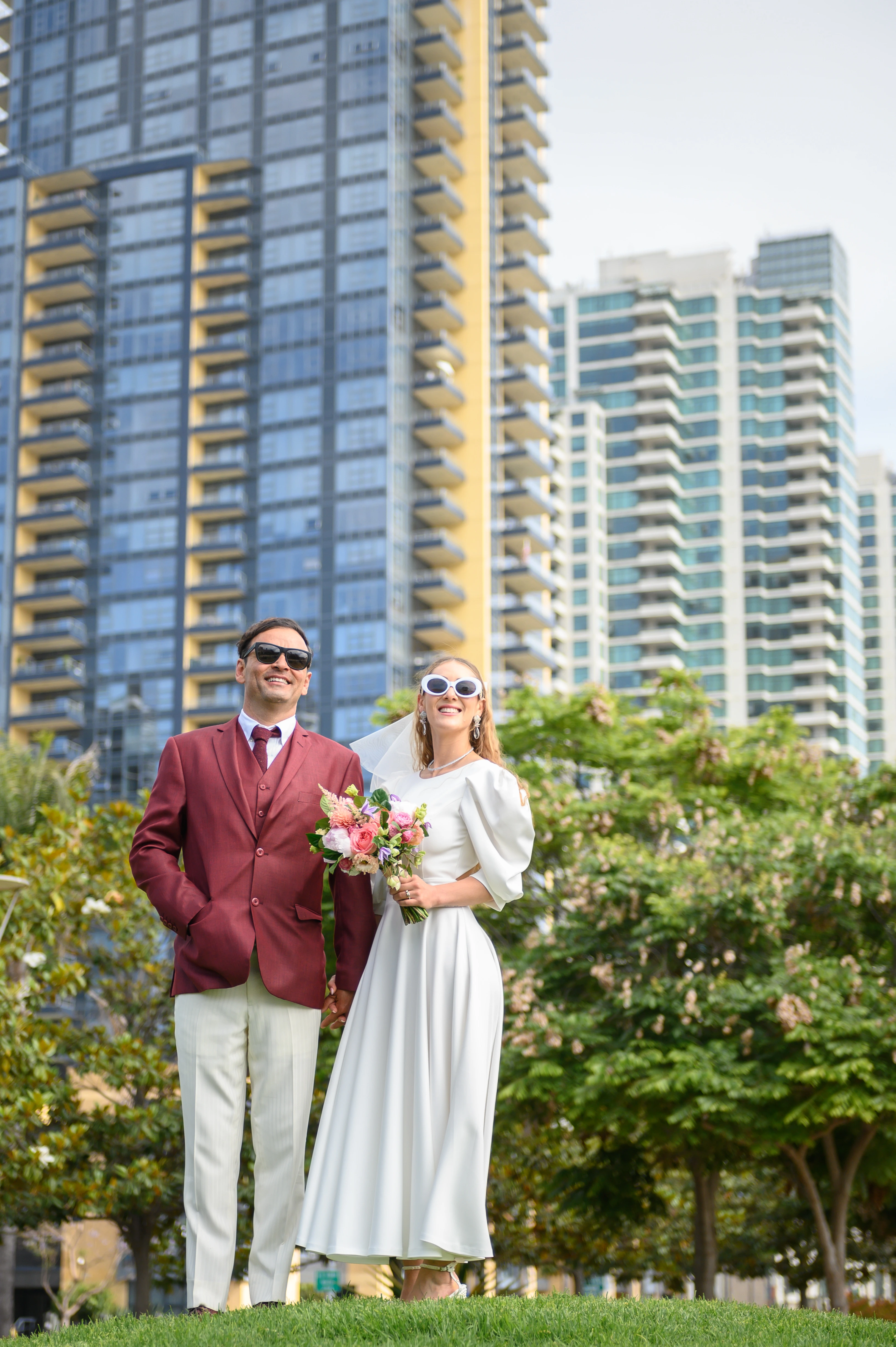 Elopement couple standing in sand diego waterfront park with downtown skyline in the background.