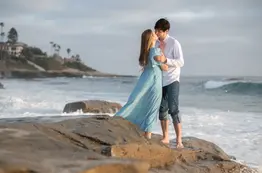 engaged couple kissing ocean Windansea Beach