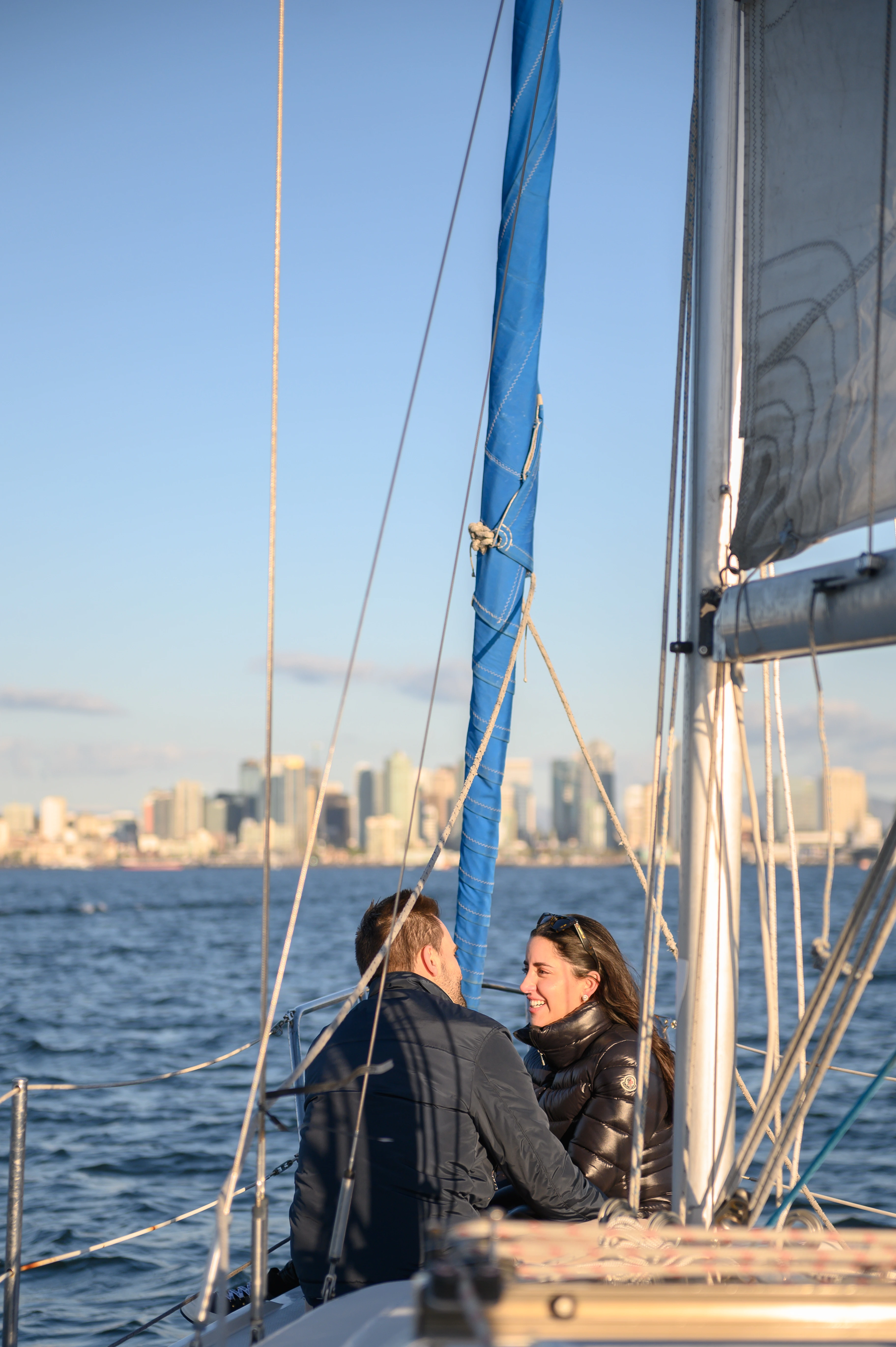 Couple sharing an intimate moment on a sailboat in San Diego, showcasing the beauty of a romantic proposal. San Diego proposal photographer.