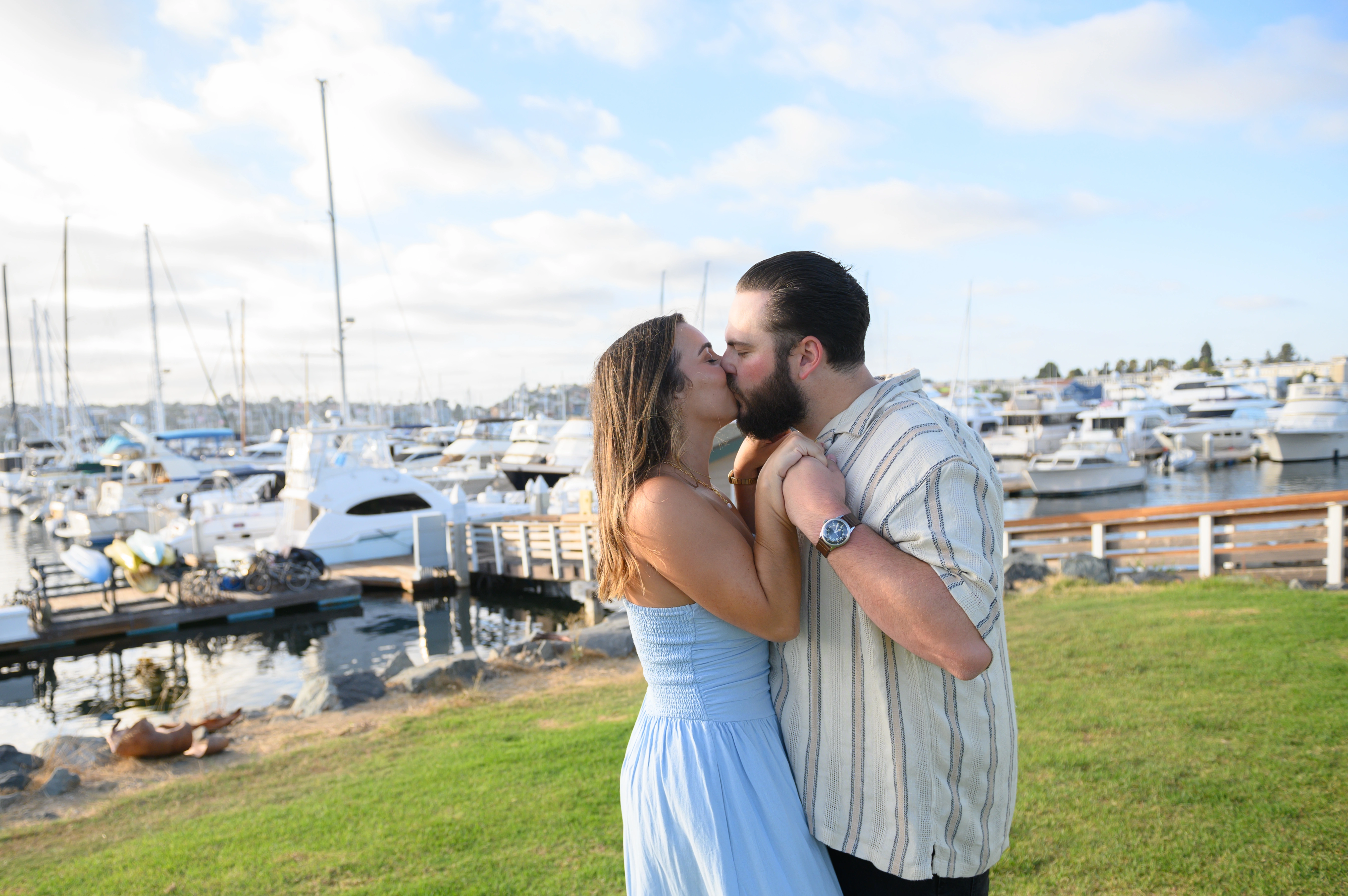 A tender embrace against the picturesque marina, showcasing the artistry of a San Diego engagement photographer.