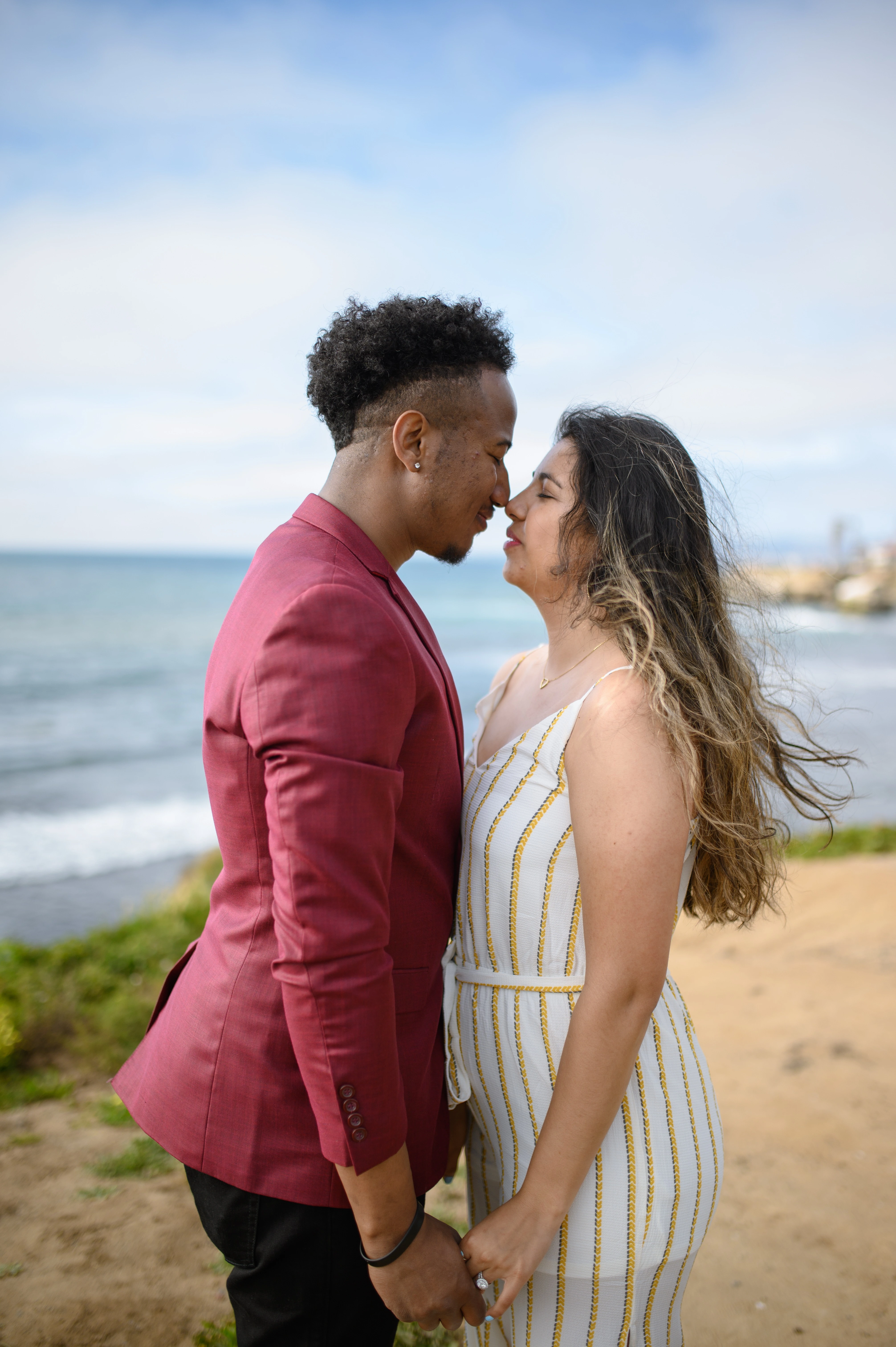 Couple sharing a tender moment at Sunset Cliffs, representing the ideal setting for an affordable San Diego proposal photographer.
