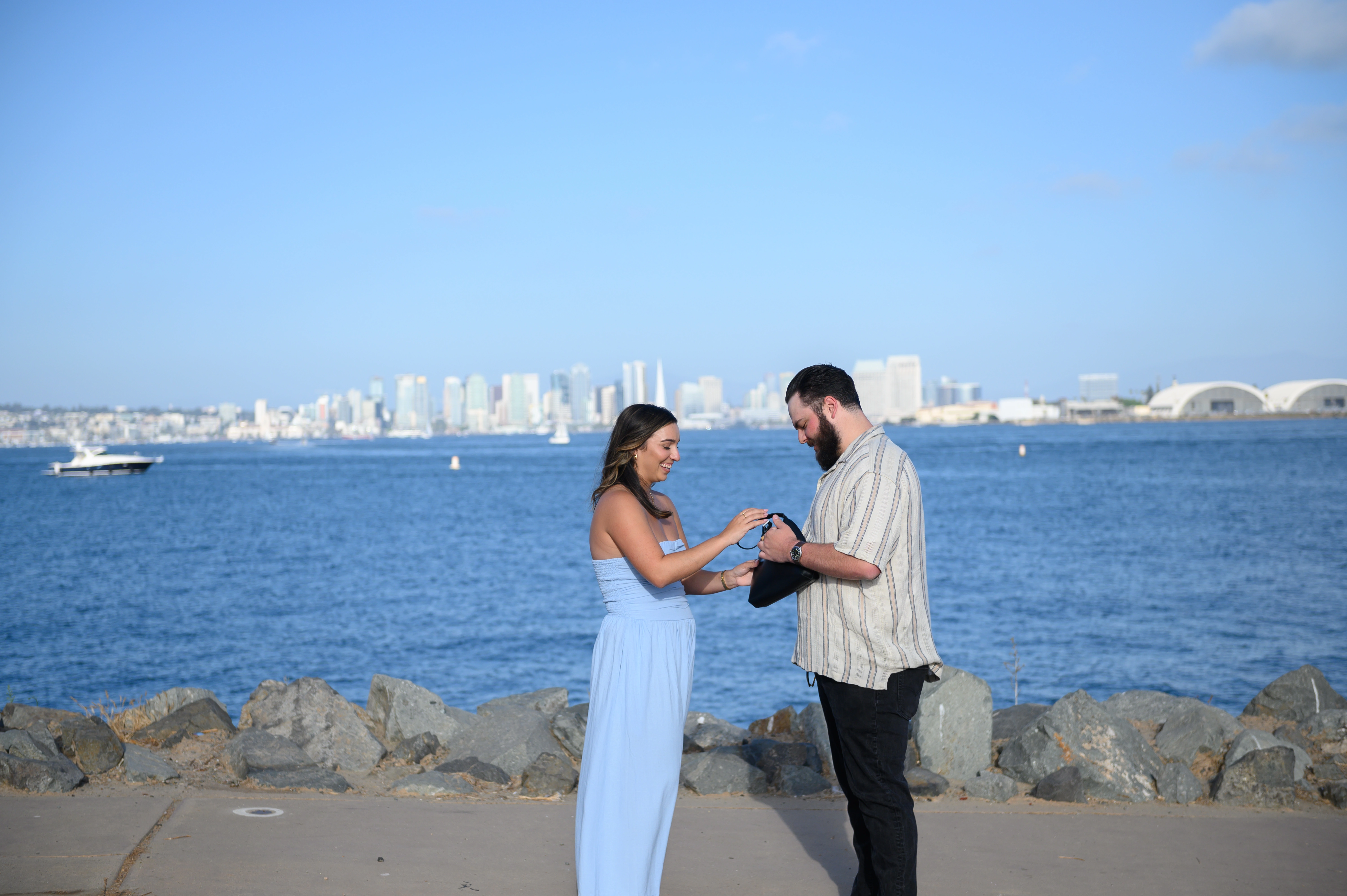 A couple engaged in a romantic proposal at the San Diego waterfront, showcasing the stunning skyline in the background. This image highlights the work of a San Diego proposal photographer, perfect for couples seeking memorable engagement moments.