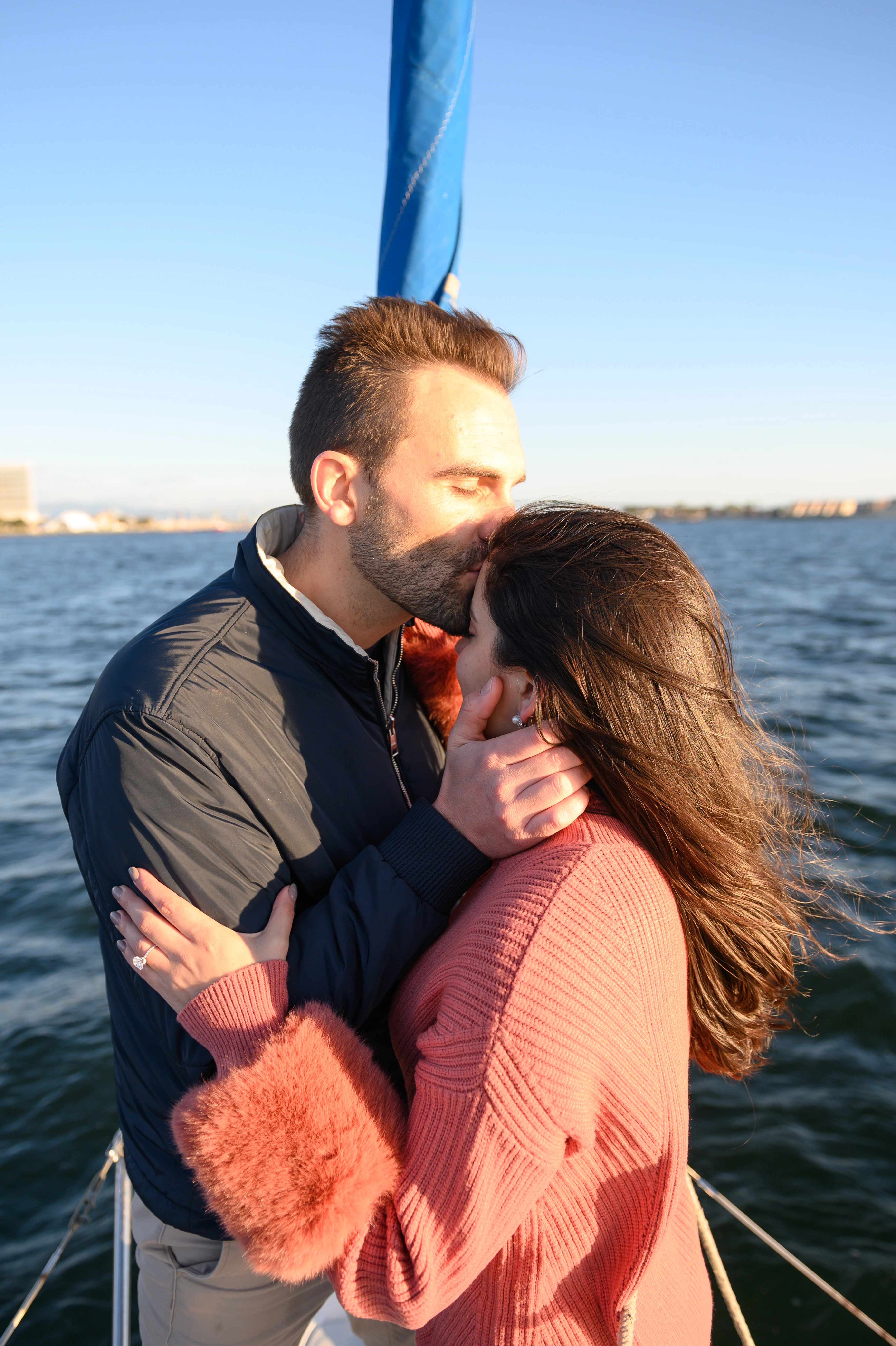 Close-up of a couple sharing a kiss during a sailboat proposal in San Diego, highlighting the romance and joy of engagement. Best San Diego proposal photographer capturing love.