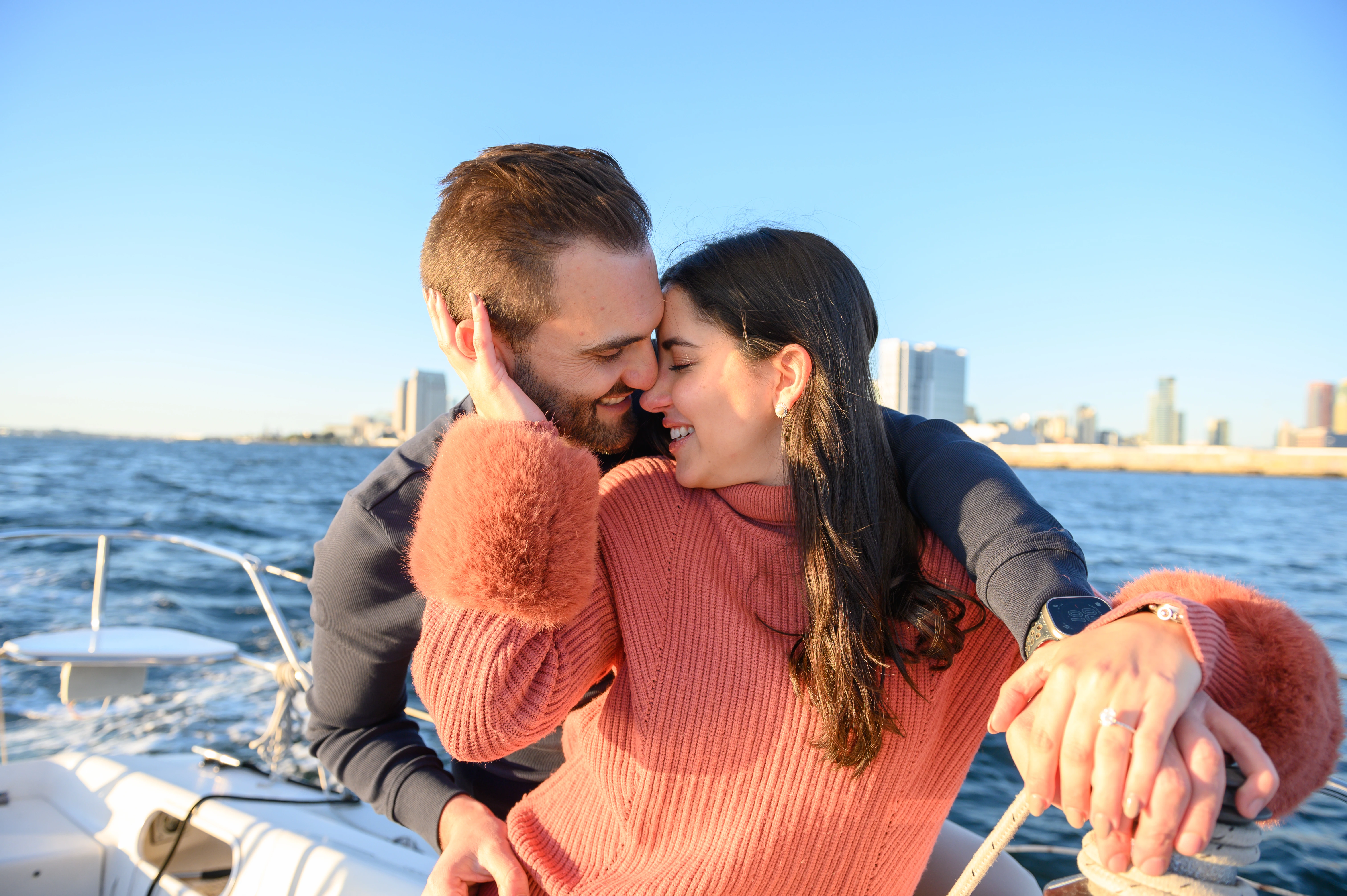 Couple sharing a kiss on a sailboat in San Diego, highlighting the romance of a proposal, ideal for a romantic proposal photographer San Diego.