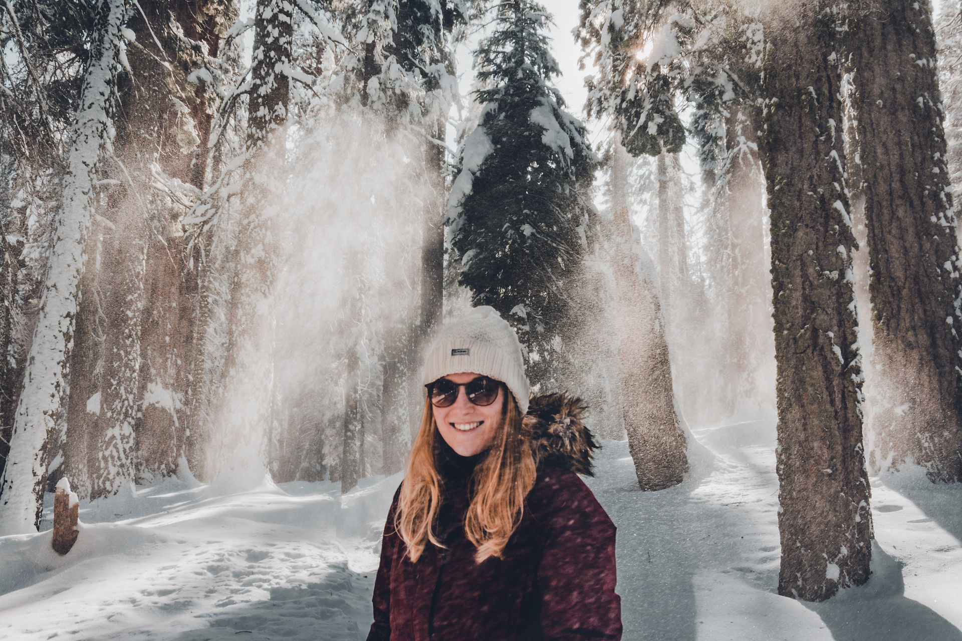 portrait of girl with hat and sunglasses in snow forest