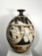 Tall oval vessel featuring bold black and cream abstract patterning on a rich brown base.