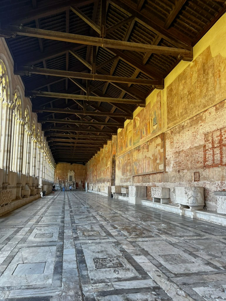 The building is an open-air corridor filled with grave markers on the floor