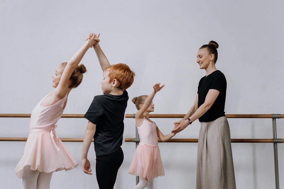 Dance teacher guiding young students during a ballet lesson 