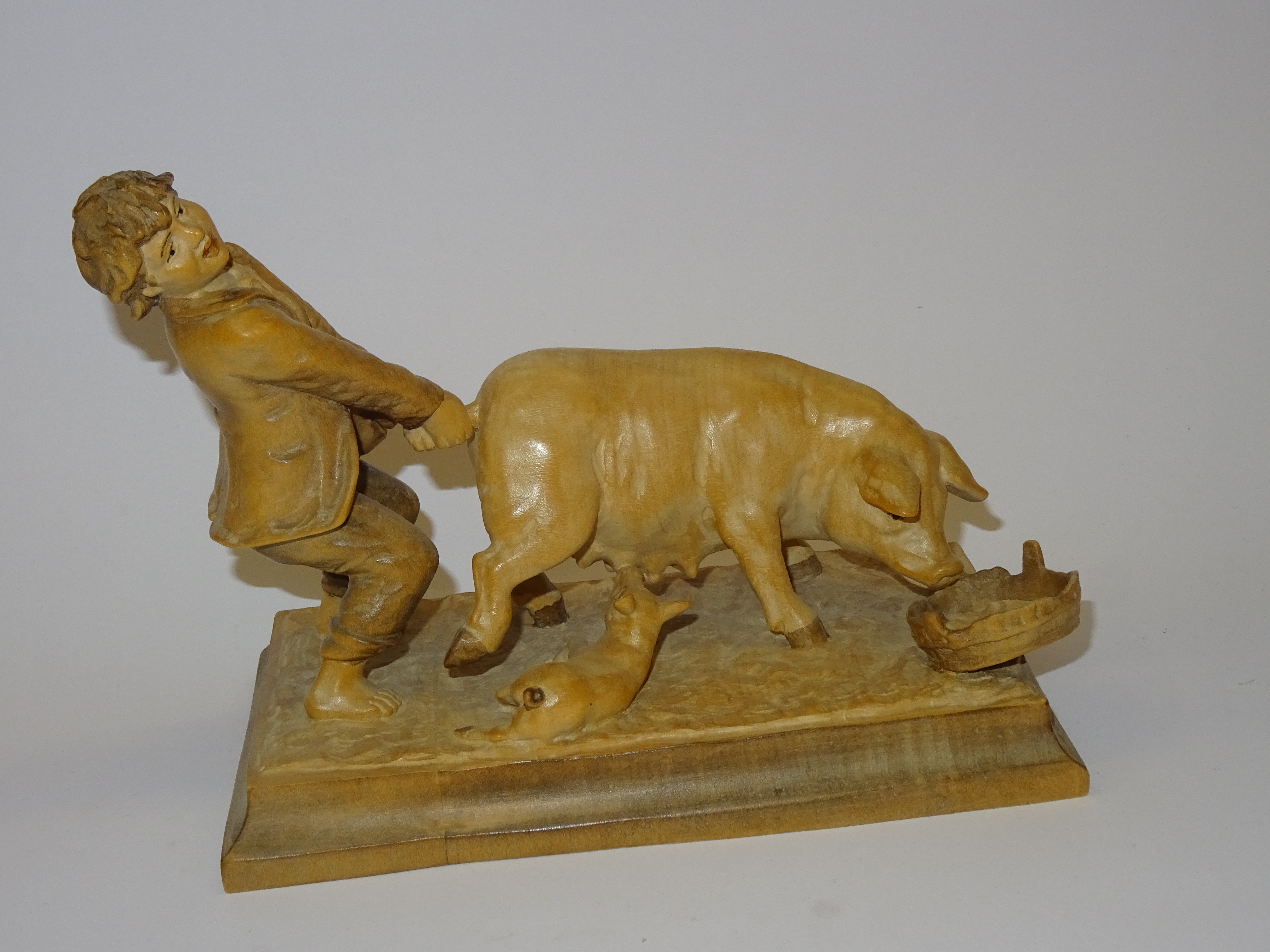 Junge mit Schwein aus Holz