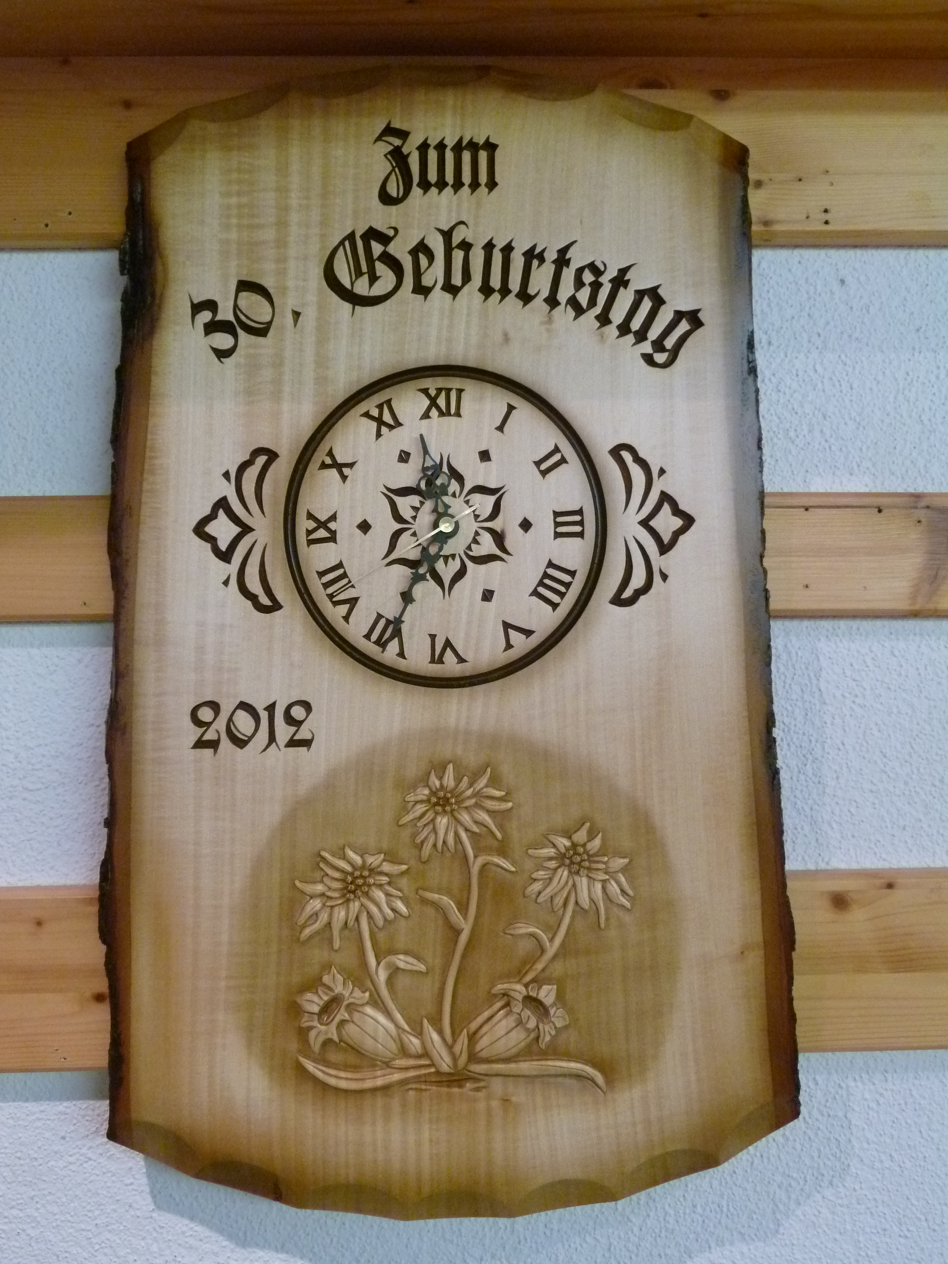 Uhr in Rindentafel mit Blumenmotiv