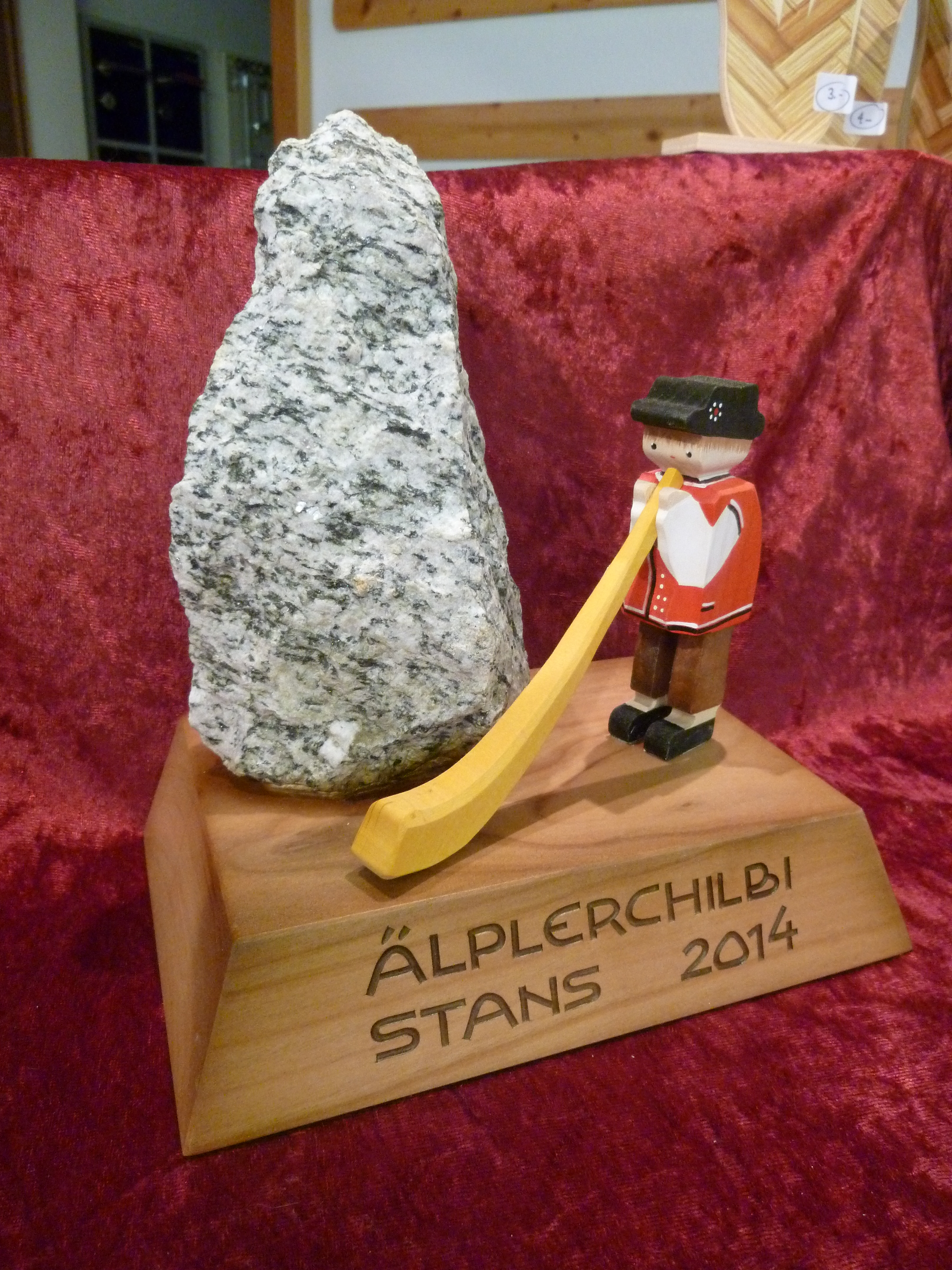 Stein auf Sockel mit Alphornbläser