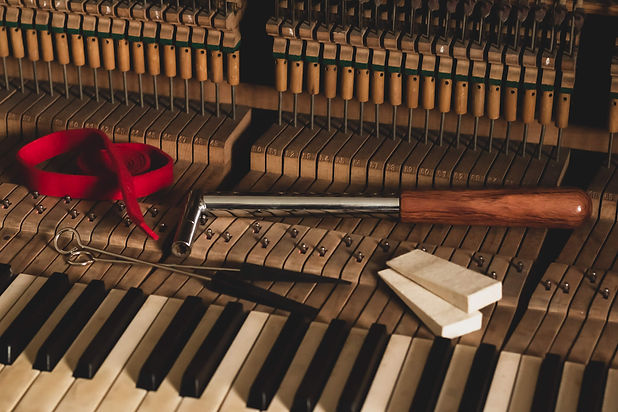 Piano tuning tools lying on piano keys