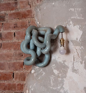 « Médusa »
Enlacée dans la terre cuite, la lumière serpente, hypnotique et sauvage. Inspirée de Méduse, elle raconte des légendes pétrifiées, des entrelacs vivant où le mystère se mêle à la clarté.

Grés blanc émaillé vert d'eau 