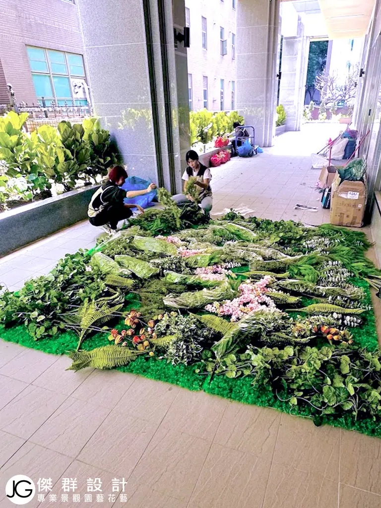 鋪設高擬真人造花草於植物牆基底上預備從天花板上吊掛