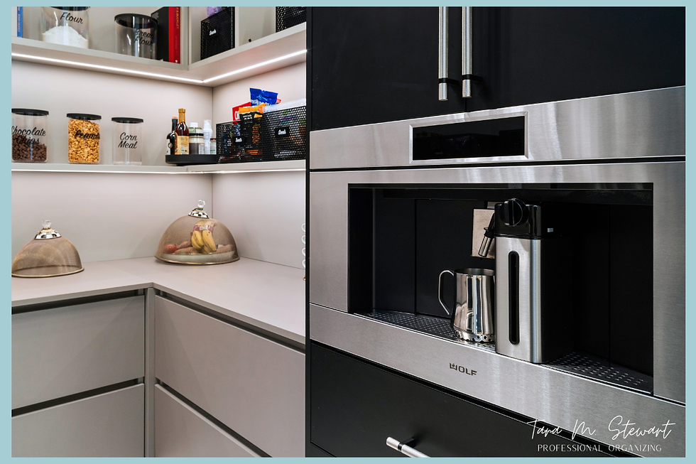Built-in stainless steel Wolf espresso and coffee machine positioned at the entrance of a custom walk-in pantry organized by Tara M. Stewart Professional Organizing.
