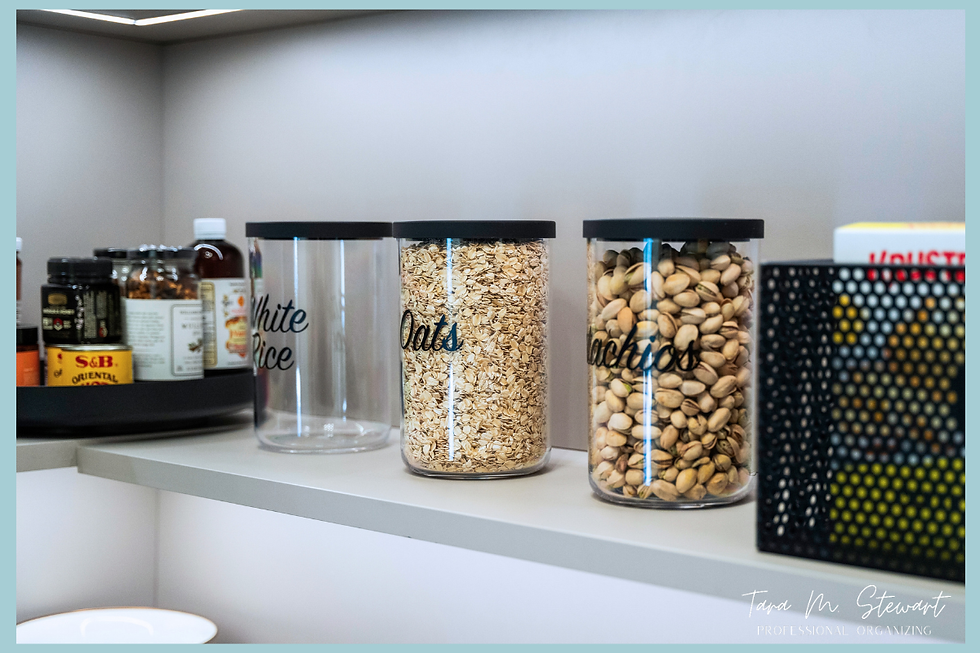 Eye-level view of clear airtight canisters filled with white rice, oats, and pistachios labeled with custom black script labels on a pantry shelf, organized by Tara M. Stewart Professional Organizing.