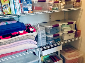 Organized small closet with labeled clear bins, folded blankets, games, and craft supplies neatly arranged on deep wire shelves, designed for flexible family storage by professional organizer Tara M. Stewart