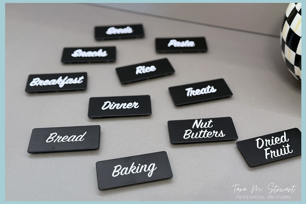 Flat-lay view of custom black magnetic pantry labels with white script categories including Baking, Bread, Snacks, and Treats created for a luxury Lexington home setup by Tara M. Stewart Professional Organizing.