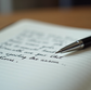 open notebook with ink pen and handwritten text
