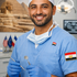 Middle Eastern Dentist in Blue Scubs with US and Egyptian Flags in background