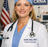 CRNa at nurses' station with American flag in the corner