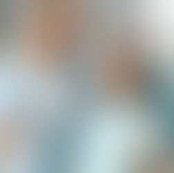 Dentist in blue scrubs smiles holding dental tools next to a patient in a dental chair with a blue bib, both looking cheerful.