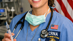 CRNA and Marine Corp Veteran in blue scrubs and surgical cap, holding a syringe