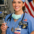 CRNA and Marine Corp Veteran in blue scrubs and surgical cap, holding a syringe