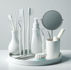 White dental tools and toothbrushes on a tray, with a small mirror and toothpaste. Minimalist setting with a clean, organized look.