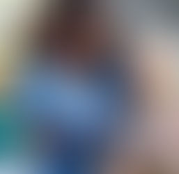 Nurse in blue scrubs uses a stethoscope on a smiling elderly person in a cozy room. Bright window light and a peaceful atmosphere.