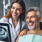 Dentist and patient smiling in a dental office. X-ray visible on screen. The mood is cheerful. Background features dental equipment.