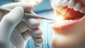 Dentist's gloved hand using a tool in a patient's open mouth under bright dental lights. Background shows a blue clinical setting