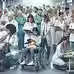 A busy hospital scene with diverse medical staff in white coats and scrubs, a woman nursing a baby in a wheelchair, conveying care and urgency.