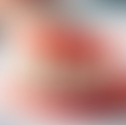 lose-up of a set of realistic dentures with pink gums and white teeth, resting on a white surface, displaying lifelike detail.