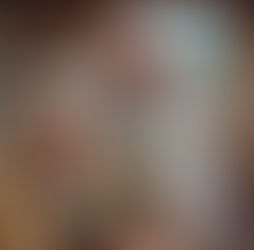 Dentist checks a child's teeth in a cozy wooden room with mountain views. The child holds a teddy bear. Dentist's coat reads "Viernat."